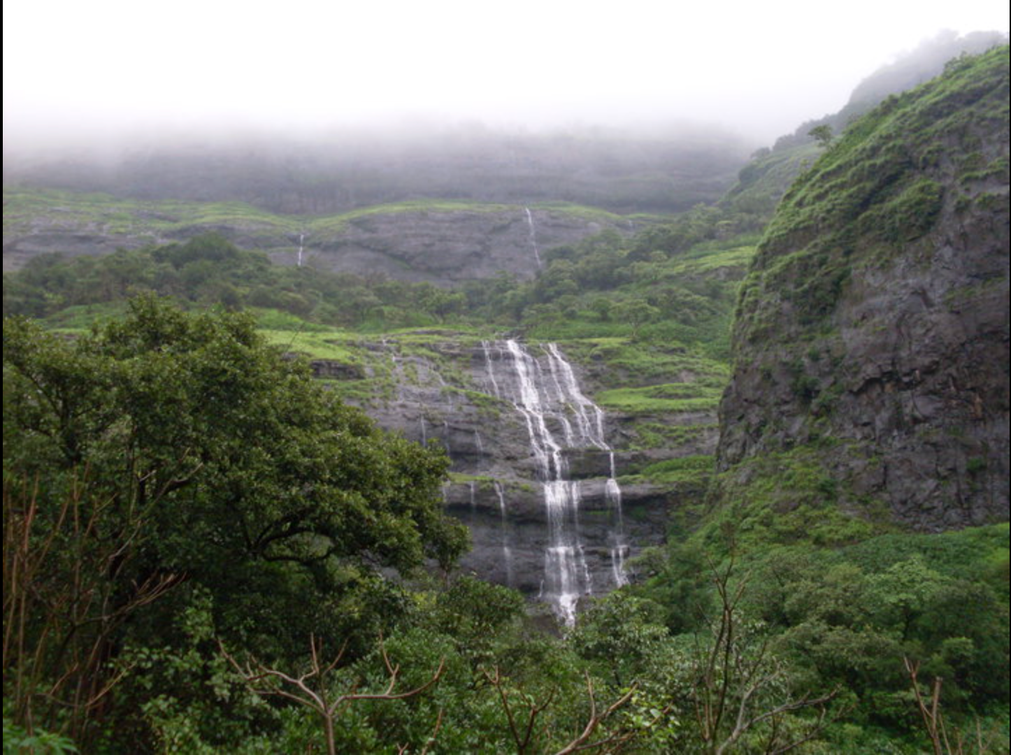 Lush waterfalls and green valleys on the descent from Harishchandragad to Pachnai in monsoon